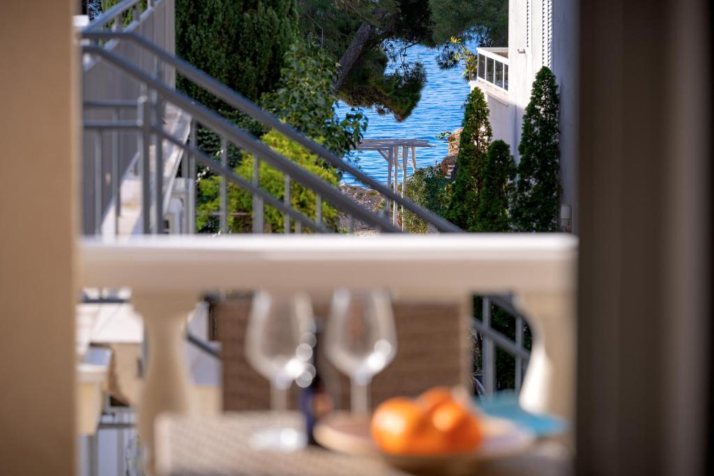 a view of a pool from a balcony with wine glasses at Villa Rajski Dvor in Bol