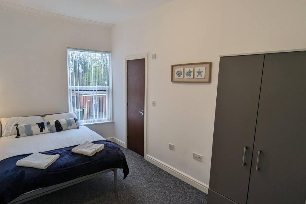a bedroom with a bed with two towels on it at 4 bed house parking Wi-Fi garden in Wallasey