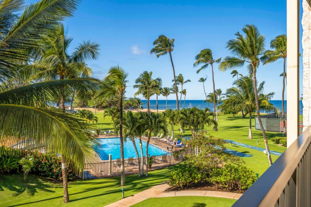 Vom Balkon eines Resorts genießen Sie Pool- und Strandblick. in der Unterkunft Maui Sunset in Kihei