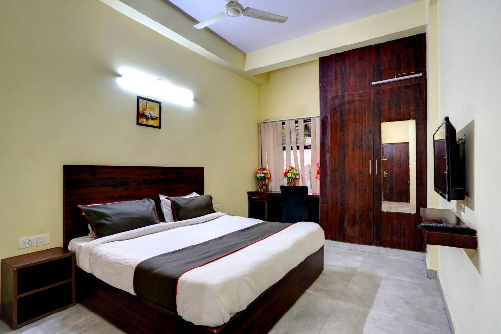 um quarto com uma cama grande e uma televisão em Collection O Hotel Liv Inn em Ghaziabad