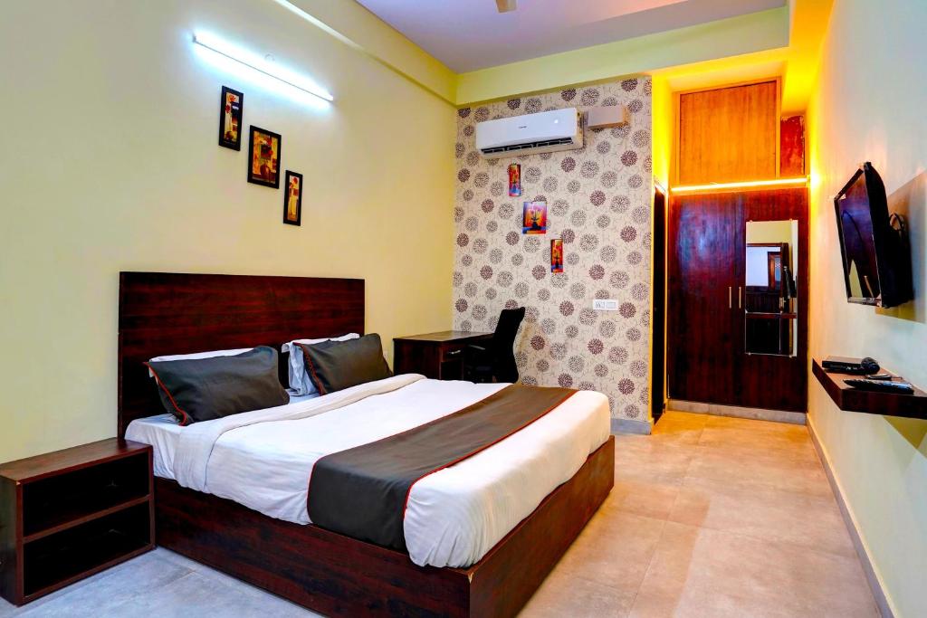 a bedroom with a large bed and a television at Collection O Hotel Liv Inn in Ghaziabad