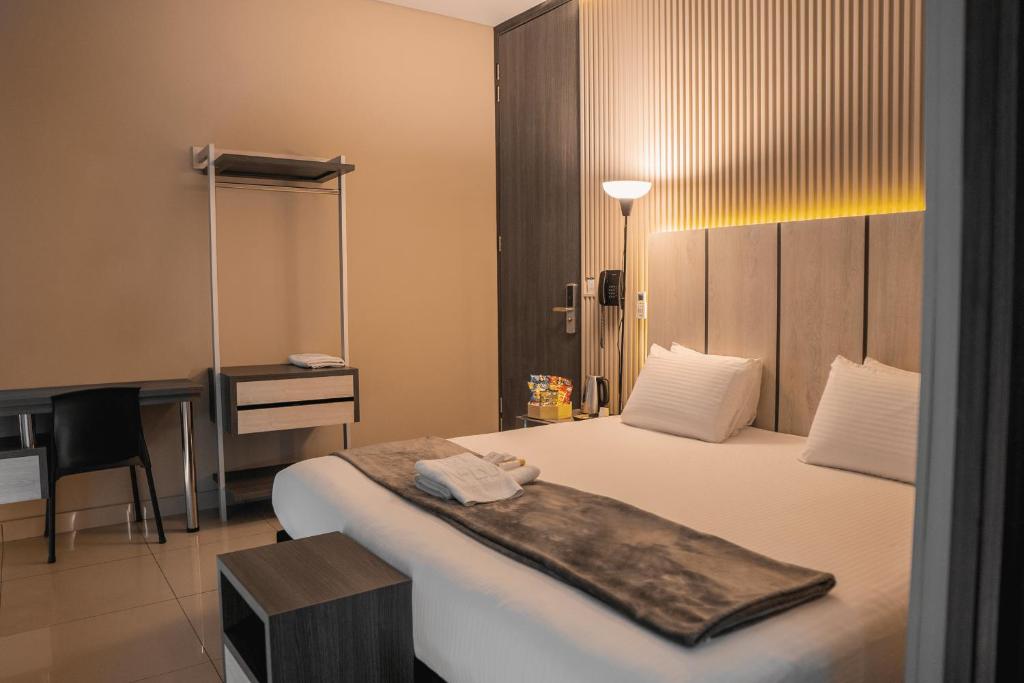 una camera d'albergo con un grande letto e una scrivania di HOTEL NABU VALLEDUPAR a Valledupar