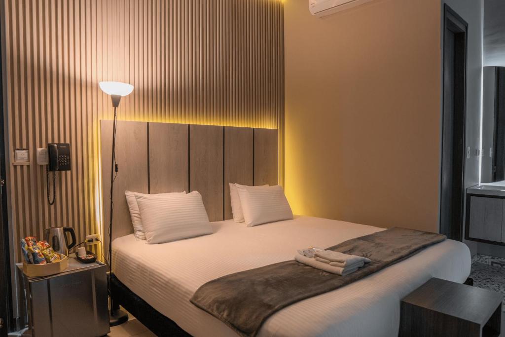 a bedroom with a large bed with white sheets at HOTEL NABU VALLEDUPAR in Valledupar