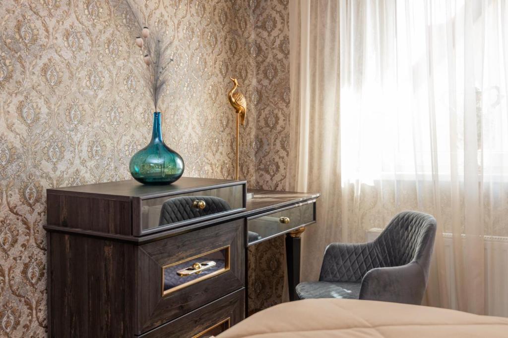a bedroom with a dresser and a vase on top of it at Feel like home Apartment SELF CHECK IN in Klaipėda