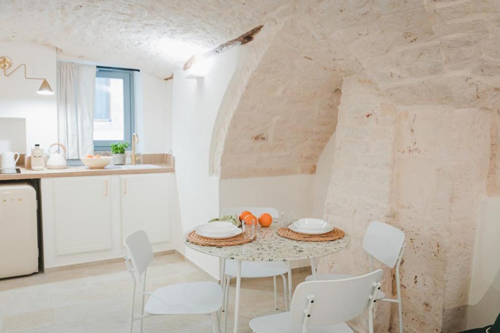 eine Küche und ein Esszimmer mit einem Tisch und Stühlen in der Unterkunft Dimore Bianche Santa Chiara in Putignano