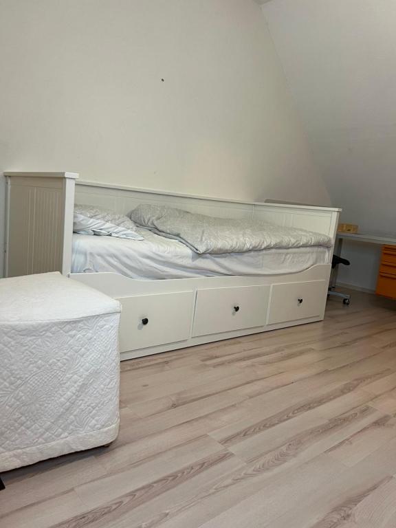 a bedroom with a white bed and a wooden floor at FireApart in Rednitzhembach