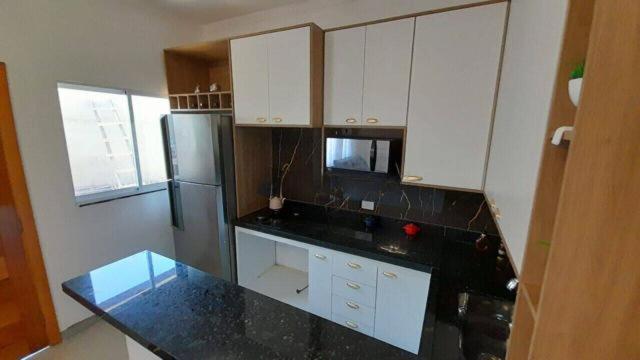 a kitchen with white cabinets and a stainless steel refrigerator at apartamento de ferias na praia em sao paulo [peruibe],rua joao atalla,280 estancia balneria Maria Helena Novais in Peruíbe