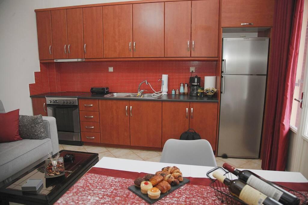 La cuisine est équipée d'armoires en bois et d'un réfrigérateur en acier inoxydable. dans l'établissement NK Dreamy Suite, à Thiva