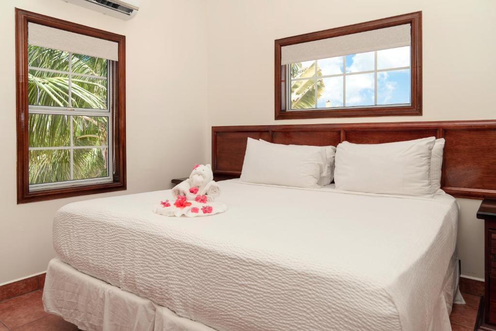 a bedroom with a white bed with a stuffed animal on it at X'tan Ha- The Waterfront in San Pedro