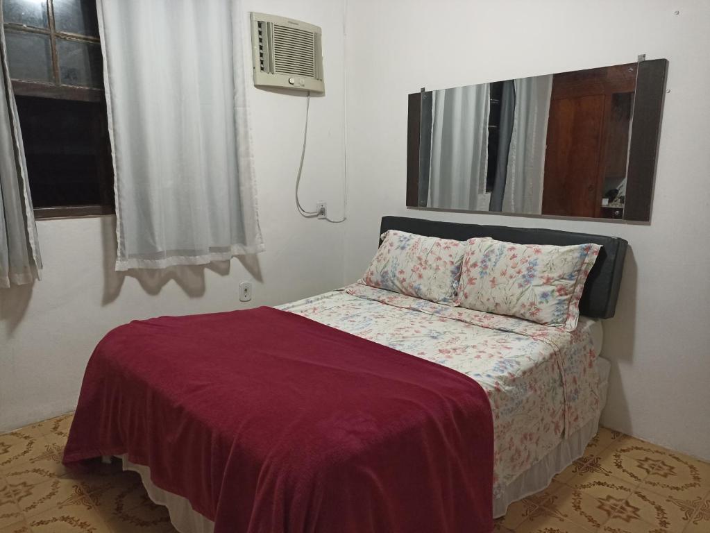 sypialnia z łóżkiem z czerwonym kocem i oknem w obiekcie Refúgio Piratininga 202 w mieście Niterói