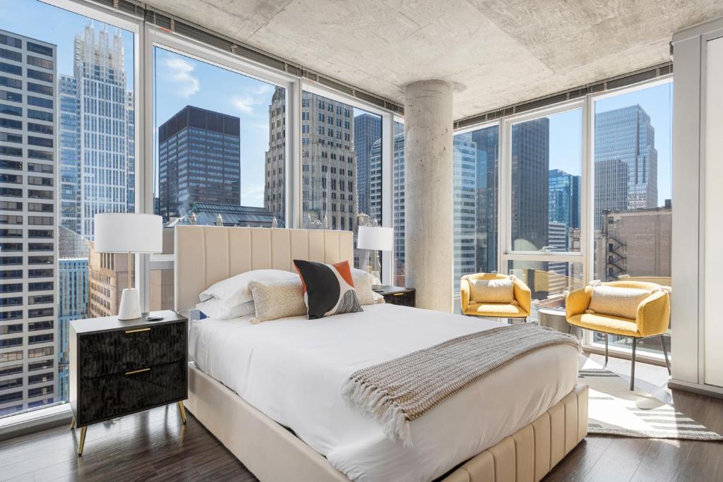 シカゴにあるLinea Luxury Living with Indoor Pool and Rooftop Views in The Loopのベッドと大きな窓のある寝室