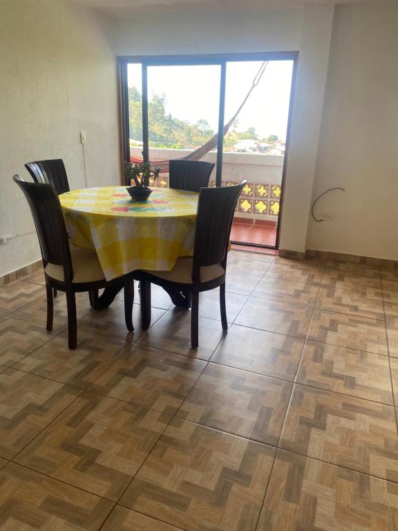 een eettafel met stoelen en een gele tafelkleed bij Casa campestre in Jericó