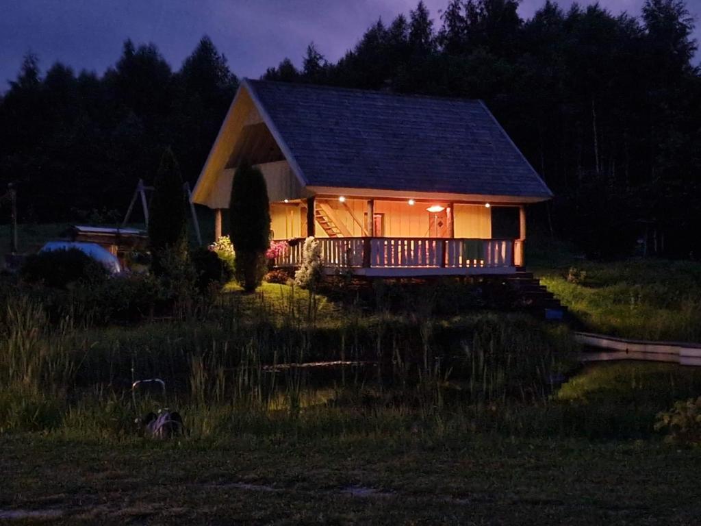 uma casa iluminada à noite num campo em Üleoja Saunamaja 