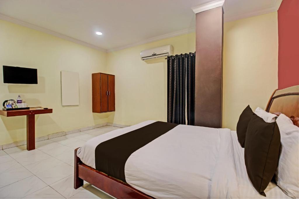 een slaapkamer met een bed en een bureau. bij Hotel Ruma Near Nampally Railway Station in Hyderabad