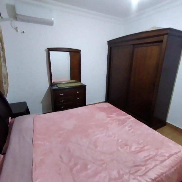 um quarto com uma cama, uma cómoda e um espelho em عمان الجاردنز خلف بن العميد em Amã