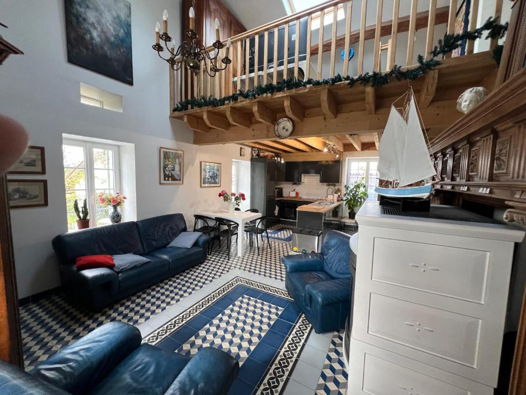 a living room with blue couches and a staircase at LA CHEVRIÈRE EN PERIGORD in Villetoureix