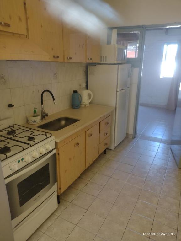 a kitchen with a stove and a sink and a refrigerator at Casa manu in La Consulta