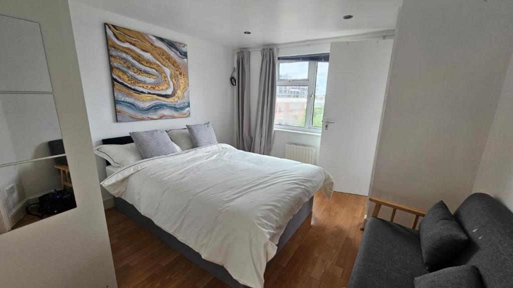 1 dormitorio pequeño con 1 cama y 1 sofá en Hayes Deluxe Inn- London, Heathrow Airport, en Hayes