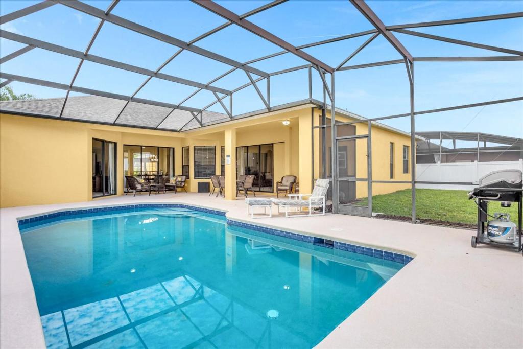 a swimming pool with a glass roof over a house at Awesome Bungalow 5BR Home - Swimming Pool and Yard in Davenport