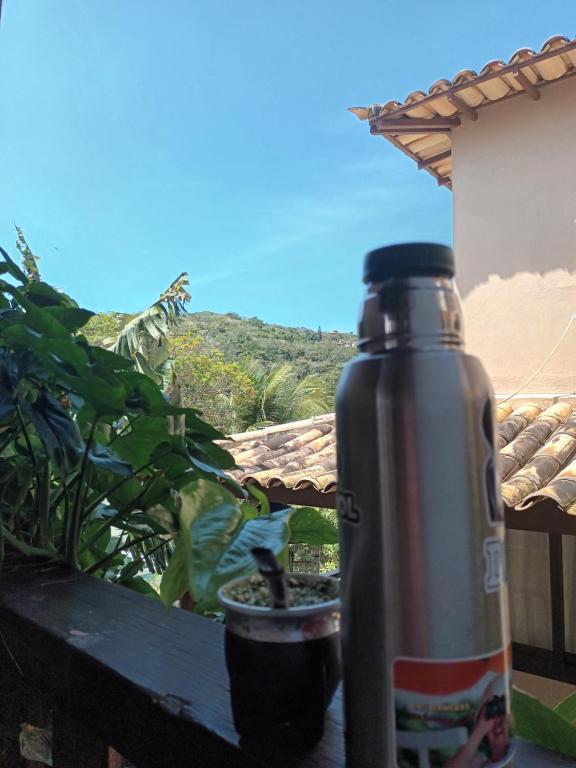 a drink bottle sitting on a table next to a plant at departamento en Geriba in Búzios