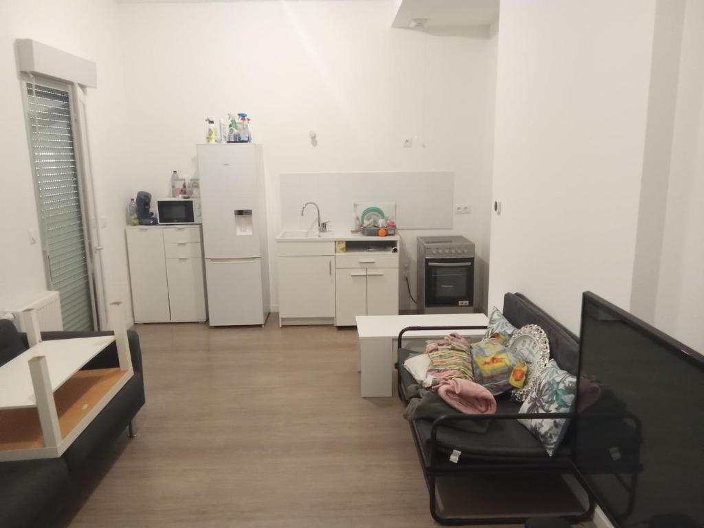 a living room with a couch and a kitchen at Chambre chez l habitants in Villepinte