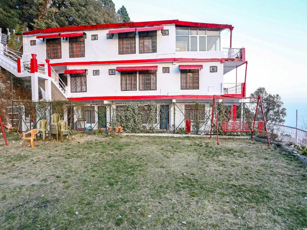 a building on top of a hill with a yard at OYO Flagship View Point Resort in Nainital