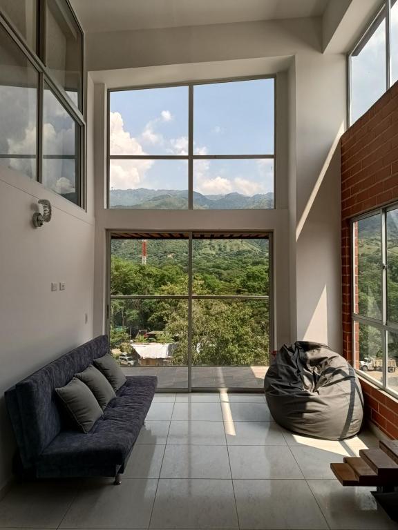 a living room with a couch and large windows at Agradable apartasol duplex in San Jerónimo