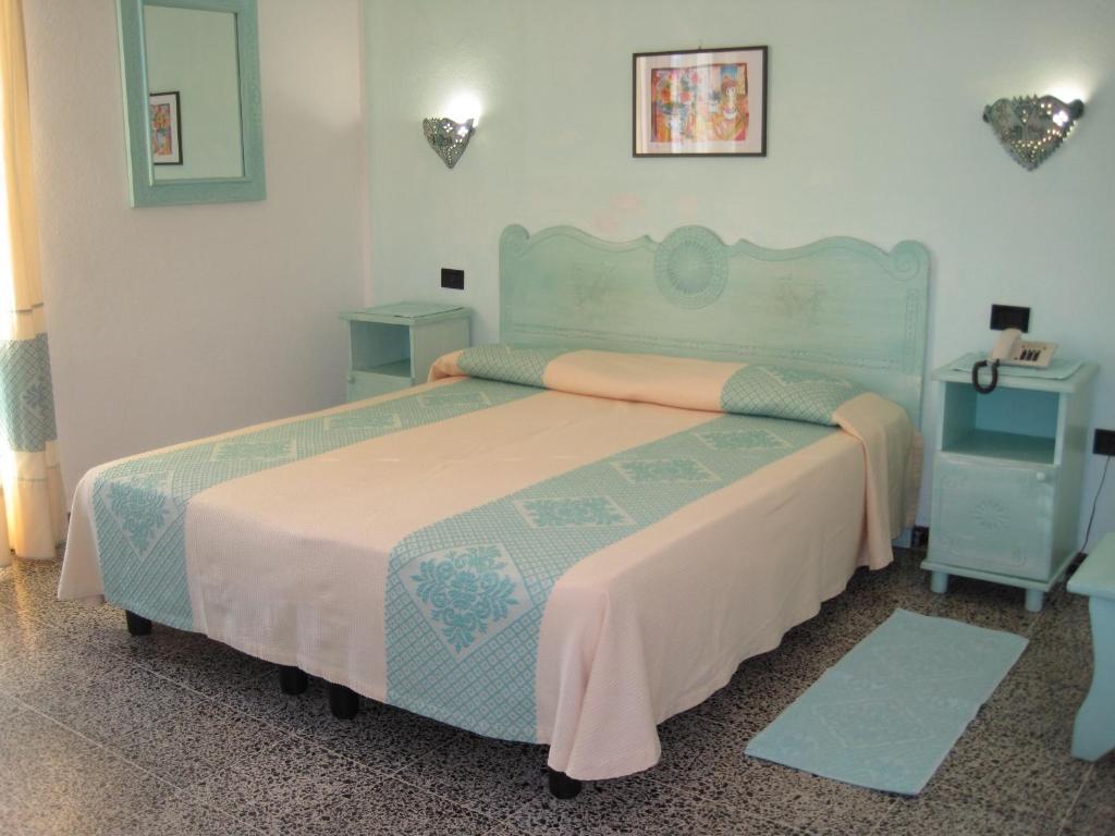 sypialnia z dużym łóżkiem i 2 szafkami nocnymi w obiekcie Hotel Moderno w mieście Santa Teresa Gallura