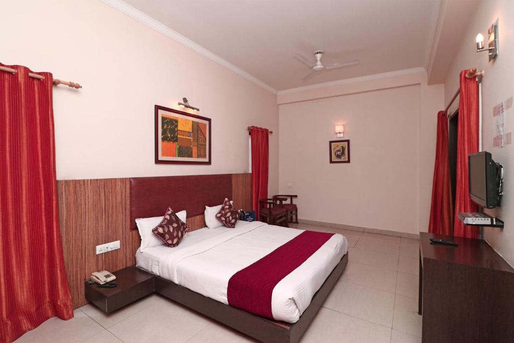 a hotel room with a bed and a tv at SPOT ON Hotel Center Point in Rāmpura