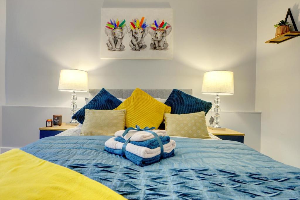 a bedroom with a blue bed with yellow and blue pillows at Coventry 2 Bedroom Apartment, Sleeps 4, Parking in Wyken