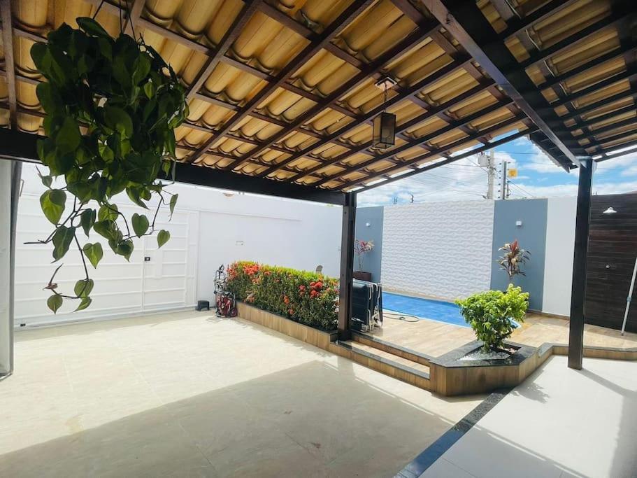 a patio with a pool and a fence with plants at Casa Aconchegante com Piscina in Petrolina