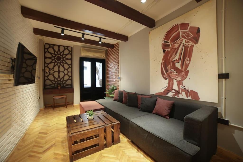 a living room with a couch and a coffee table at Chic Artist Loft in Downtown Cairo W Vintage Charm in Cairo
