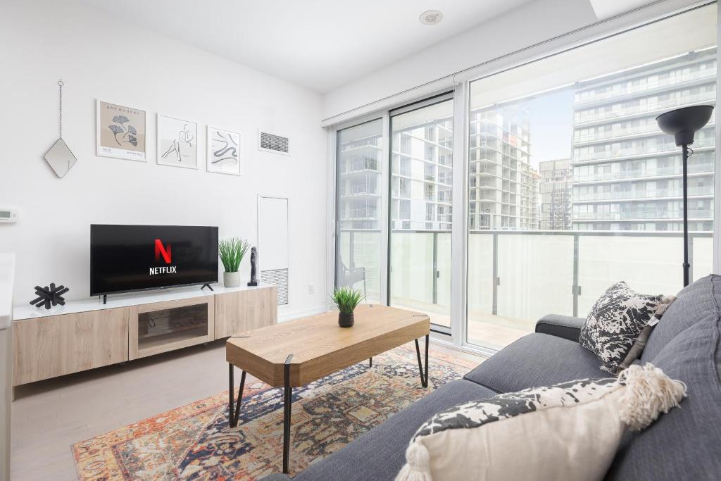 a living room with a couch and a tv at 1BD Perfect location Walk to CN Tower! in Toronto