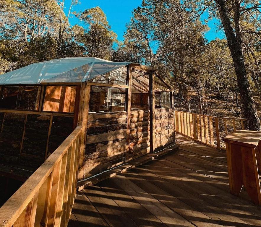 Glamping en la Sierra de Arteaga في Los Lirios: جسر خشبي فوقه خيمة