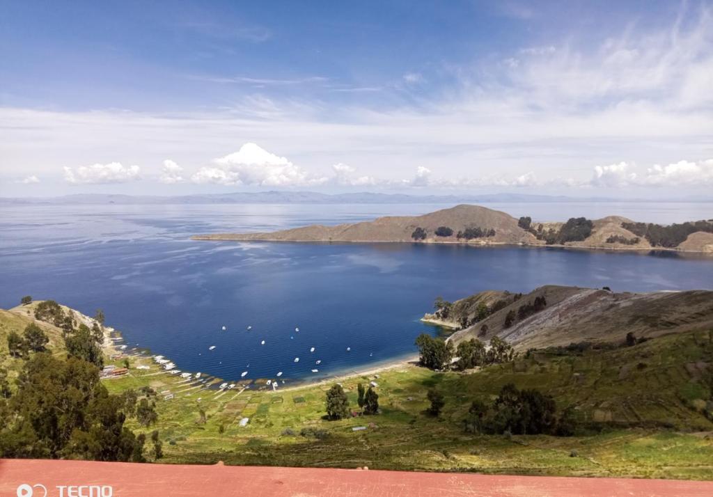 a view of a lake with boats in the water at Inti kala lodge in Comunidad Yumani