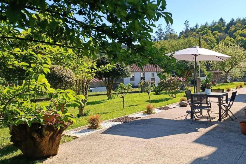 內格雷拉的住宿－Casa América，庭院配有遮阳伞和桌椅。