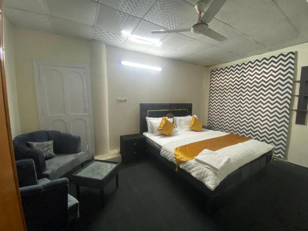 um quarto com uma cama, um sofá e uma cadeira em The Nook em Muzaffarabad