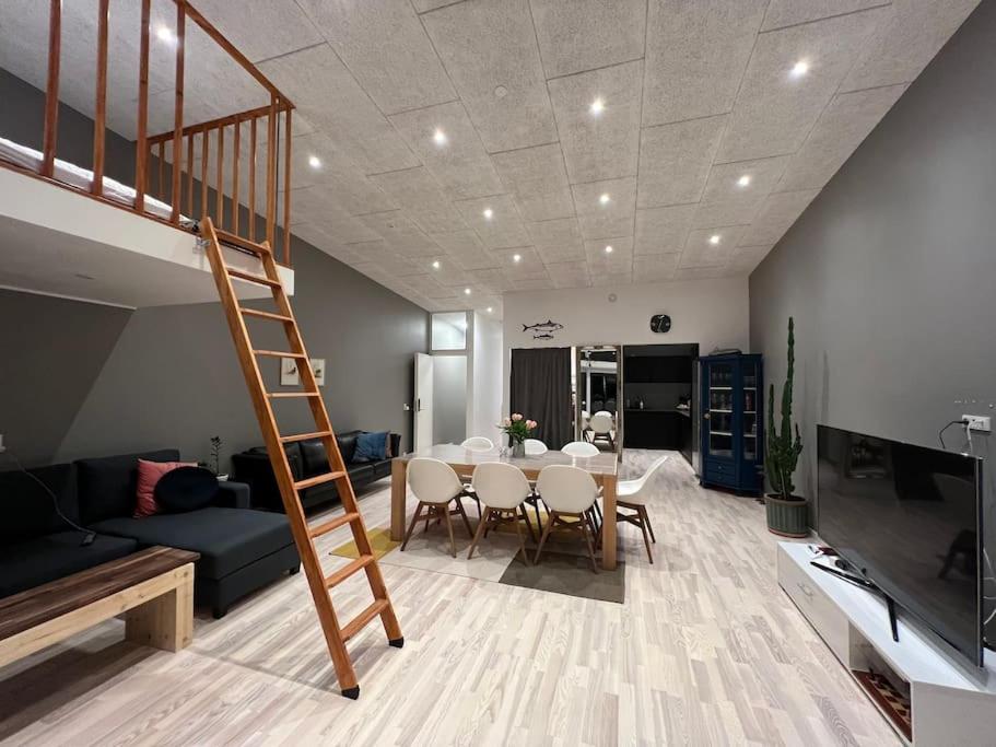 un soggiorno con tavolo da pranzo e scala di Rosie’s Neyst a Vestnanhavn