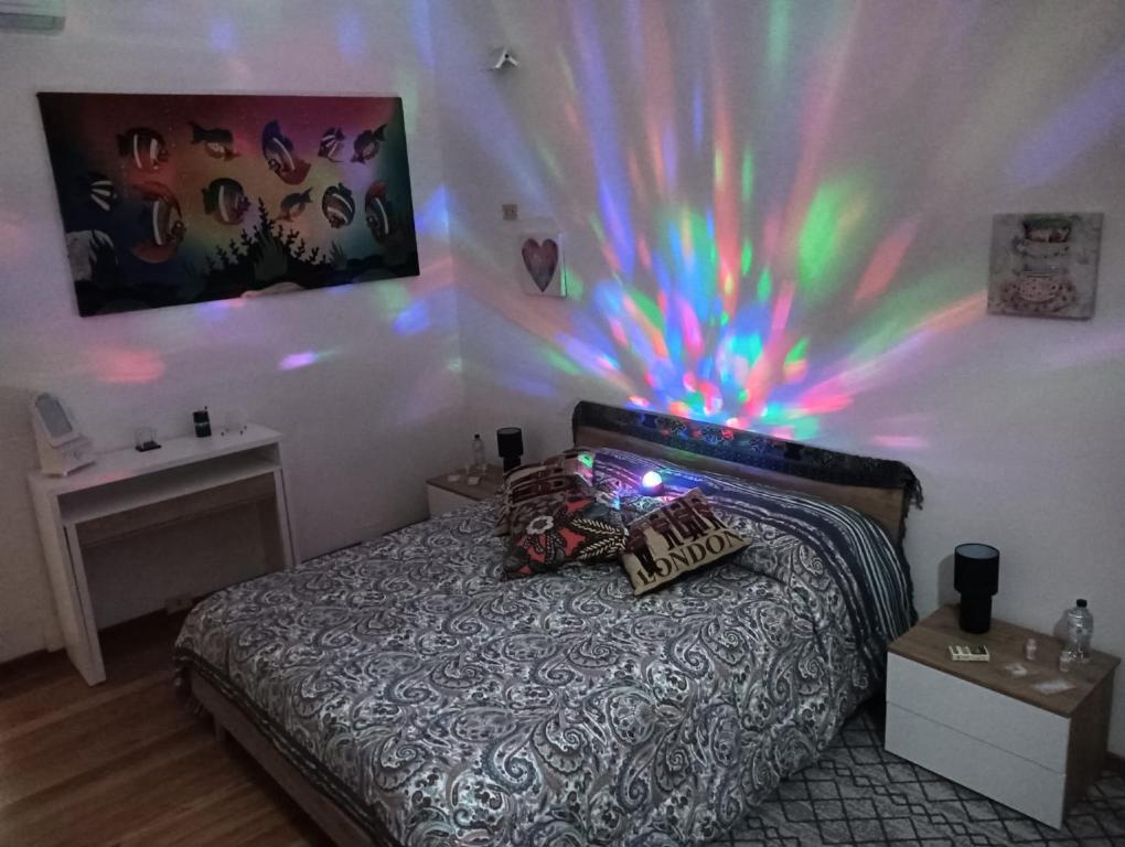- une chambre dotée d'un lit avec une lumière colorée sur le mur dans l'établissement La casa di Marilyn in Fiera, à Bologne