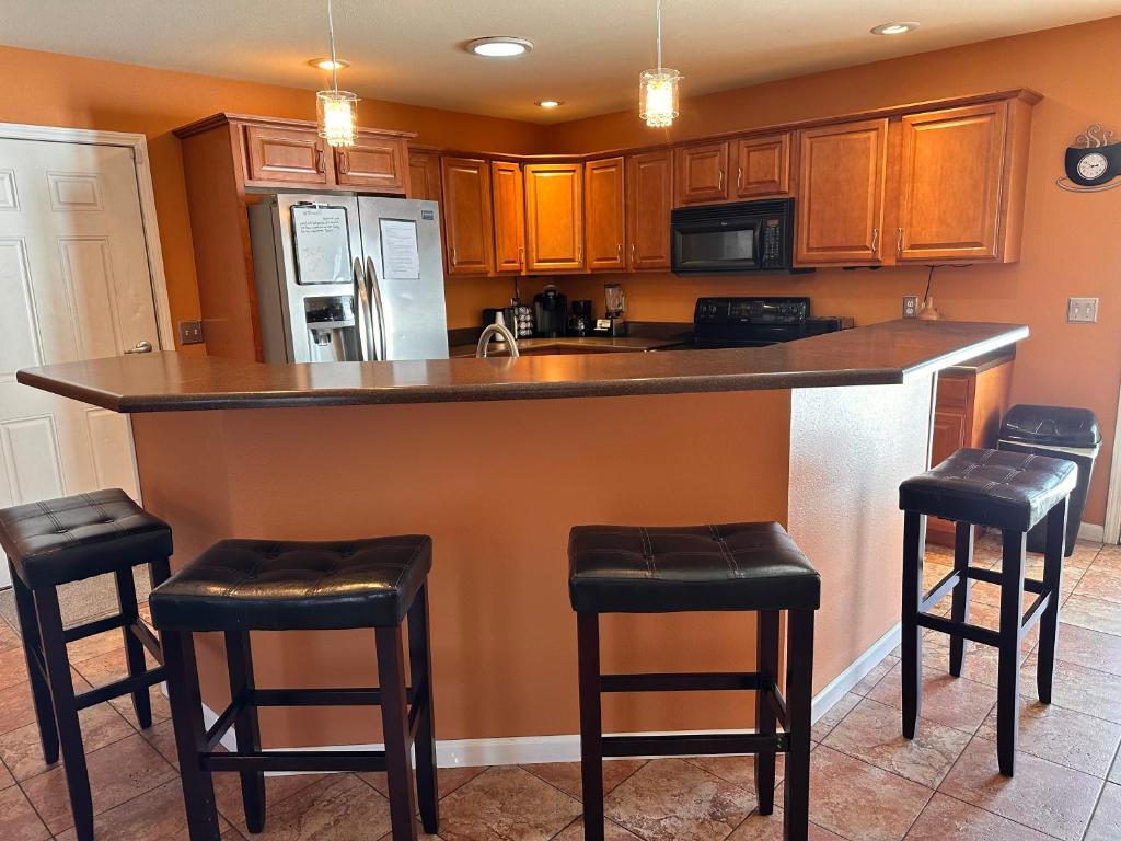 a kitchen with a bar with black stools in it at A huge Sprawling House on a large lot -15 minutes to St Louis in Belleville