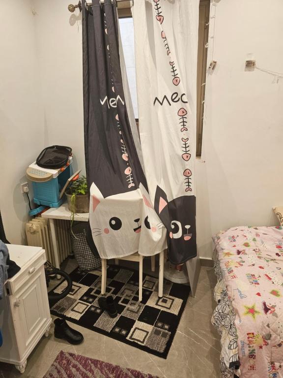 傑赫拉省的住宿－New Naseem block 3，一间卧室配有椅子和小猫窗帘
