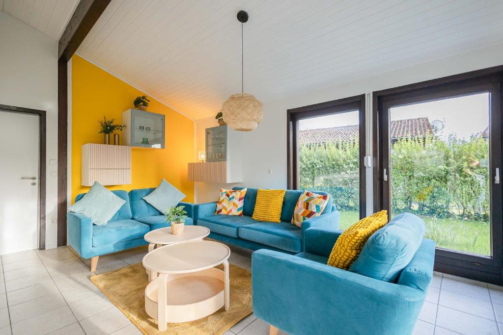 a living room with blue furniture and yellow walls at Ferienwohnpark Immenstaad am Bodensee Satteldachhaus freistehend SDS 044 in Immenstaad am Bodensee