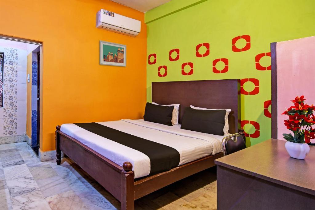 a bedroom with a bed with yellow and green walls at Chilika Residency in Bhubaneshwar