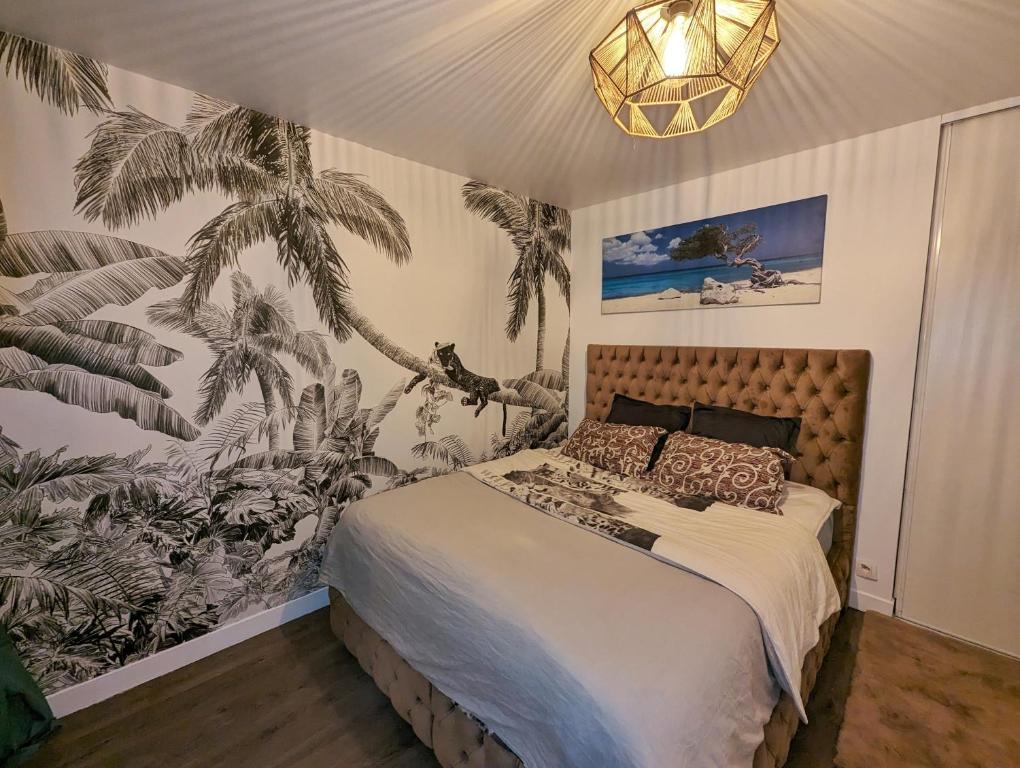 um quarto com uma cama com papel de parede de palmeira em Comfort Room I Renewed Duplex em Pantin