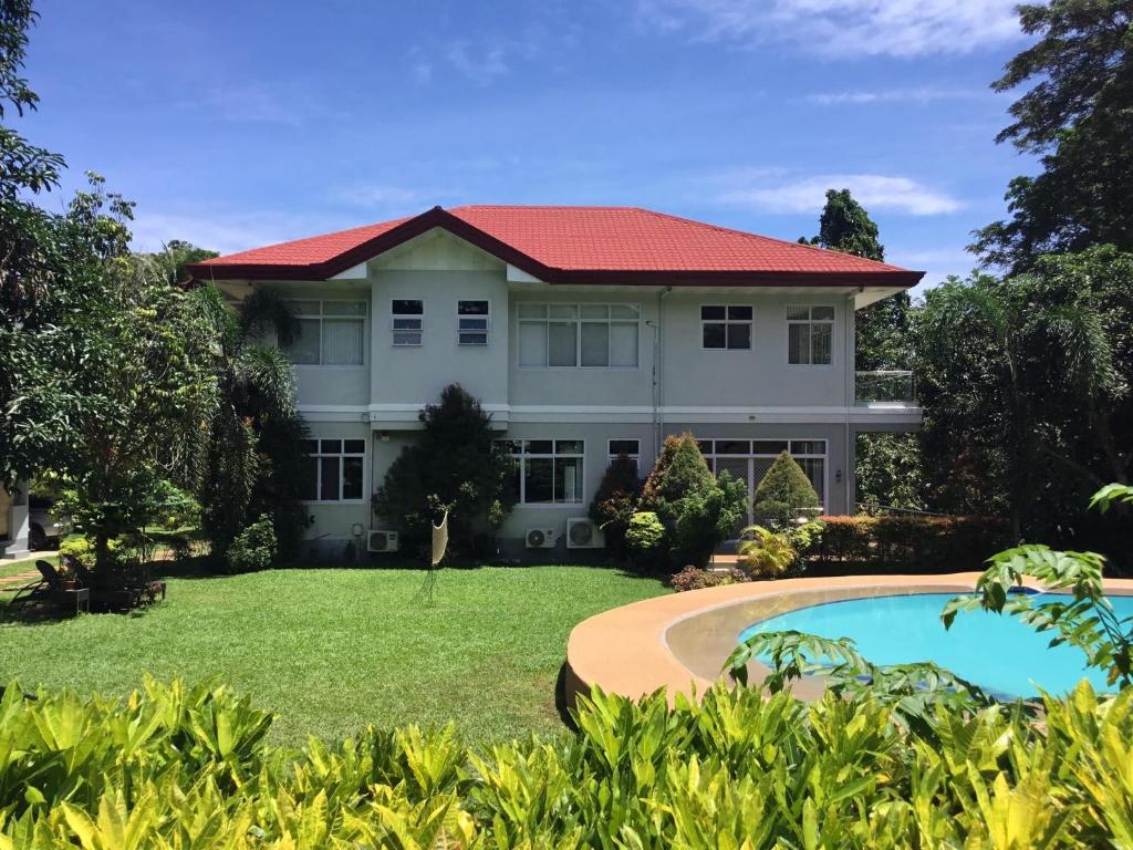 duży biały dom z czerwonym dachem w obiekcie Camiguin Lanzones Resort w Mambajao
