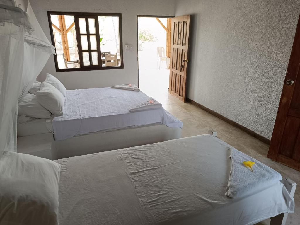 een kamer met 2 bedden en een raam bij Sierra Sagrada Tayrona in Guachaca