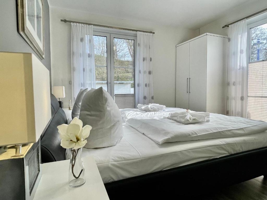 una camera da letto con un letto e un vaso di fiori su un tavolo di Haus Sonne a Thiessow