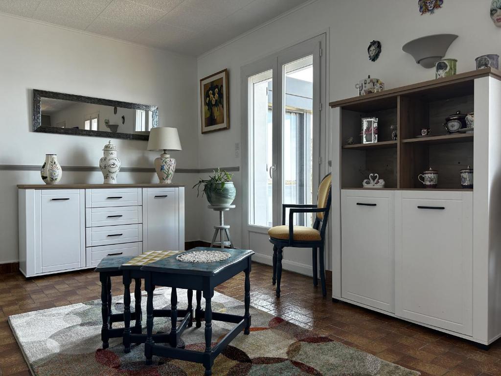 ein Wohnzimmer mit einem Tisch und weißen Schränken in der Unterkunft Maison Belz, 3 pièces, 4 personnes - FR-1-397-67 in Belz