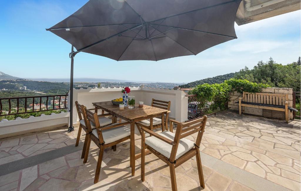 einen Tisch und Stühle mit Sonnenschirm auf einer Terrasse in der Unterkunft 3 Bedroom Lovely Apartment In Solin in Solin