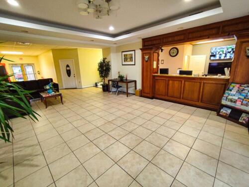 een grote kamer met een grote tegelvloer en een lobby bij Clover Inn and Suites in Shreveport